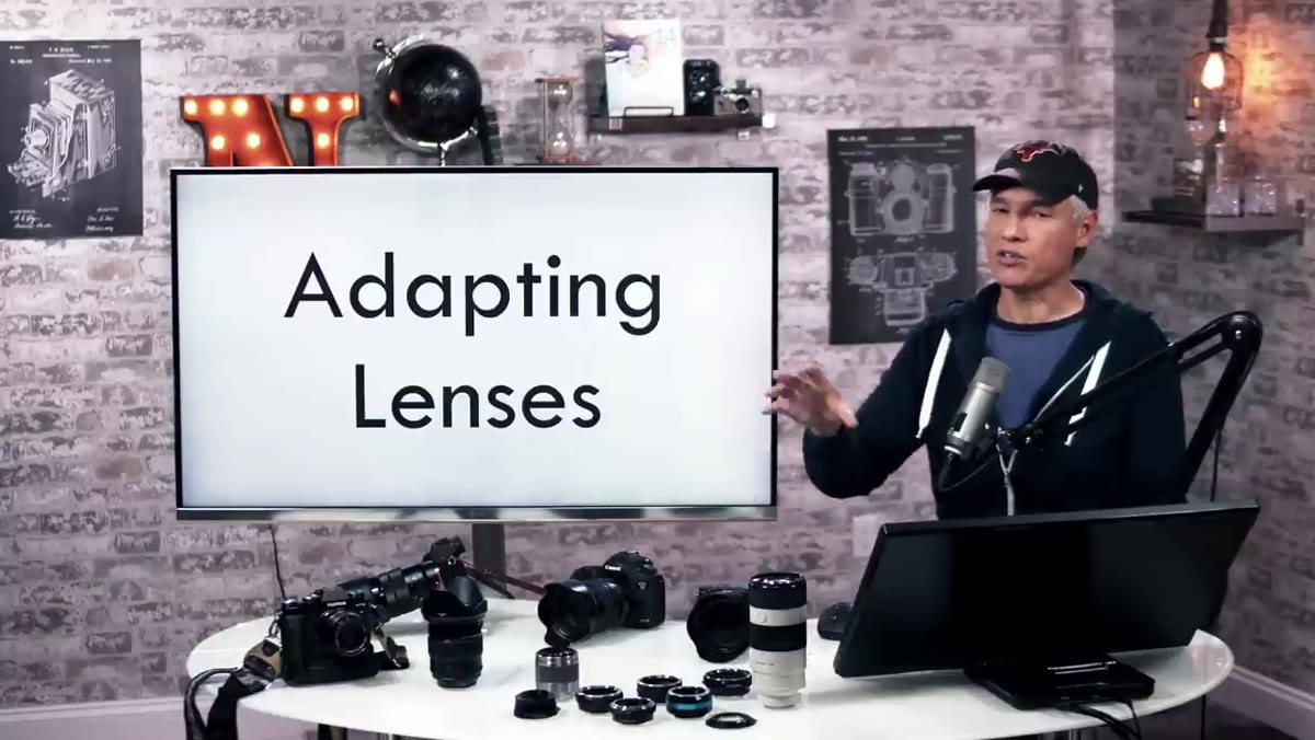 Tony holding Sony mirrorless body next to Canon DSLR body
