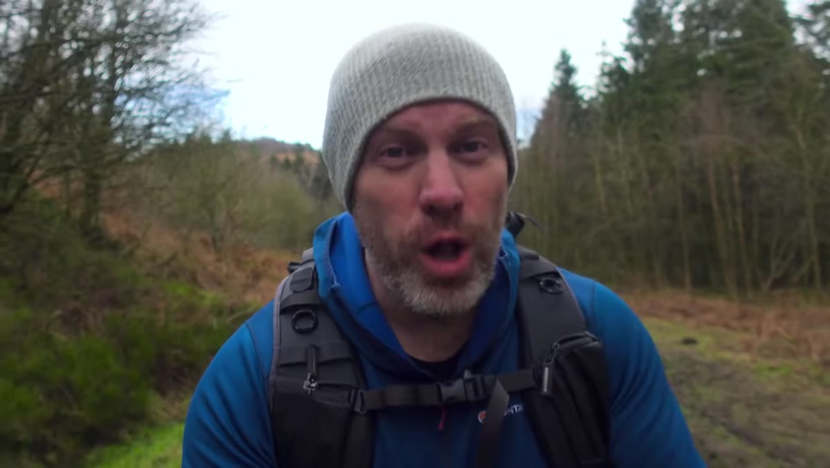 Adam introducing the gear list while hiking with camera visible