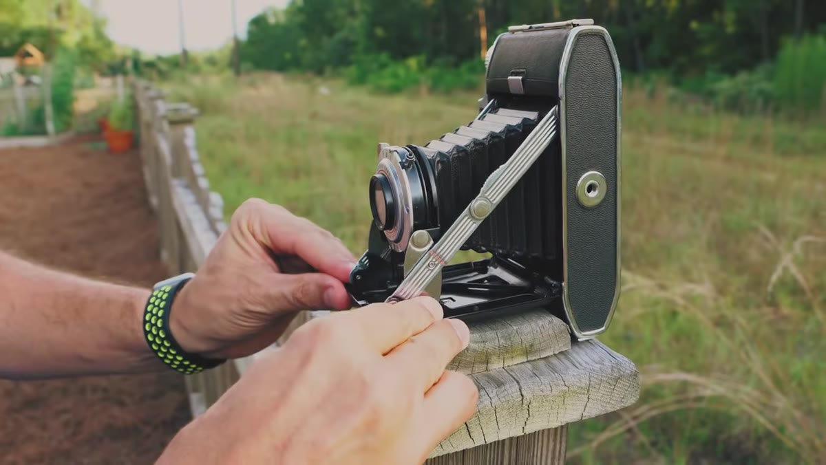 Camera on tripod aimed at subject in backyard