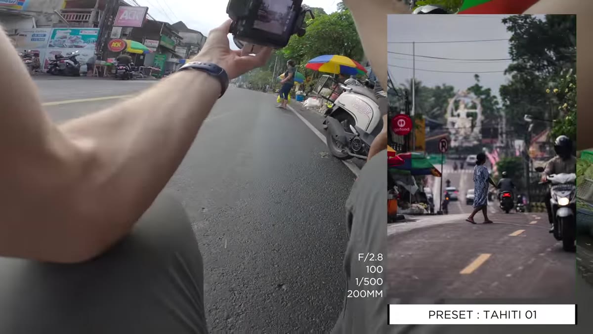 Pierre crouching low near market to capture statue in frame