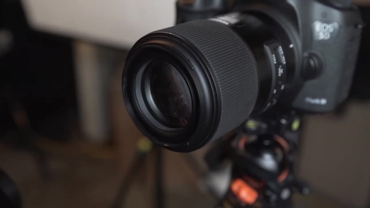 JP holding the updated 90mm lens toward camera