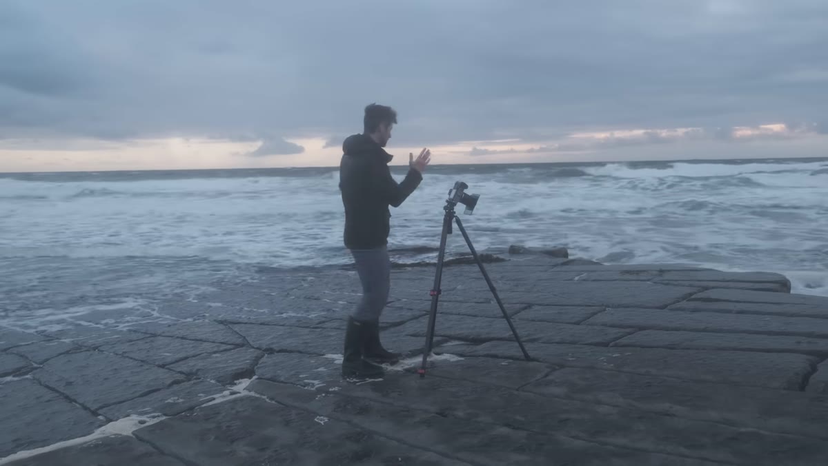 Heaton shooting in wind and spray at a rocky coastal scene