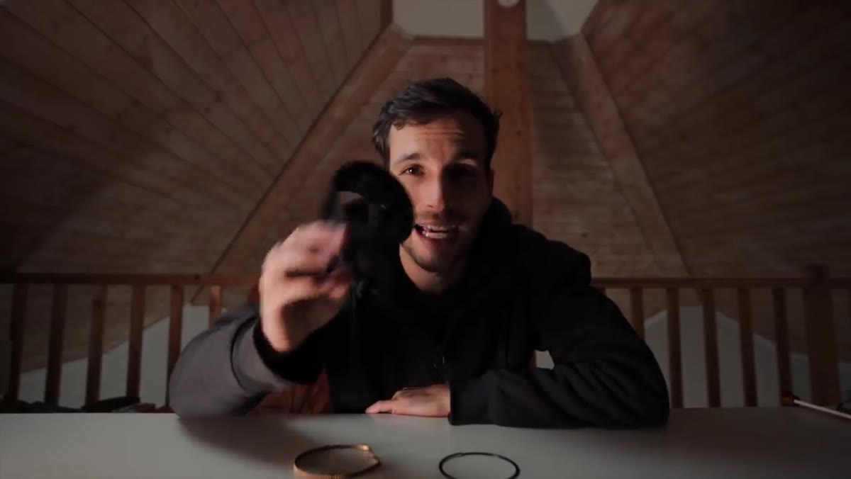 caption: Broken plastic lens component held up for camera inspection