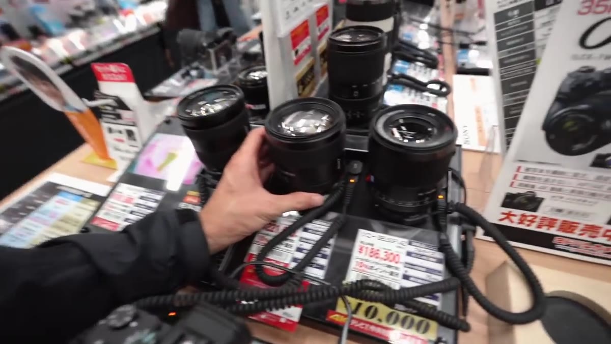 Pierre looking through 85mm f/1.4 Sony lens in store