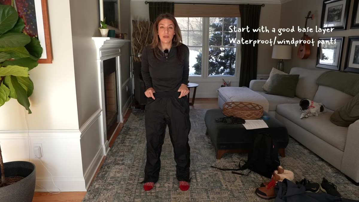 Waterproof shell pants being pulled on over base layer